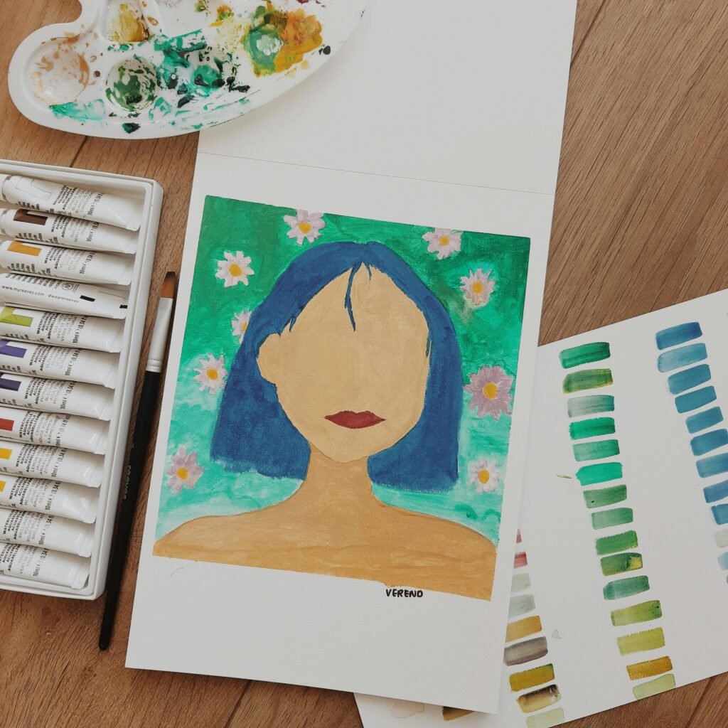 Vibrant portrait painting with nearby paint tubes and brushes on a wooden table.